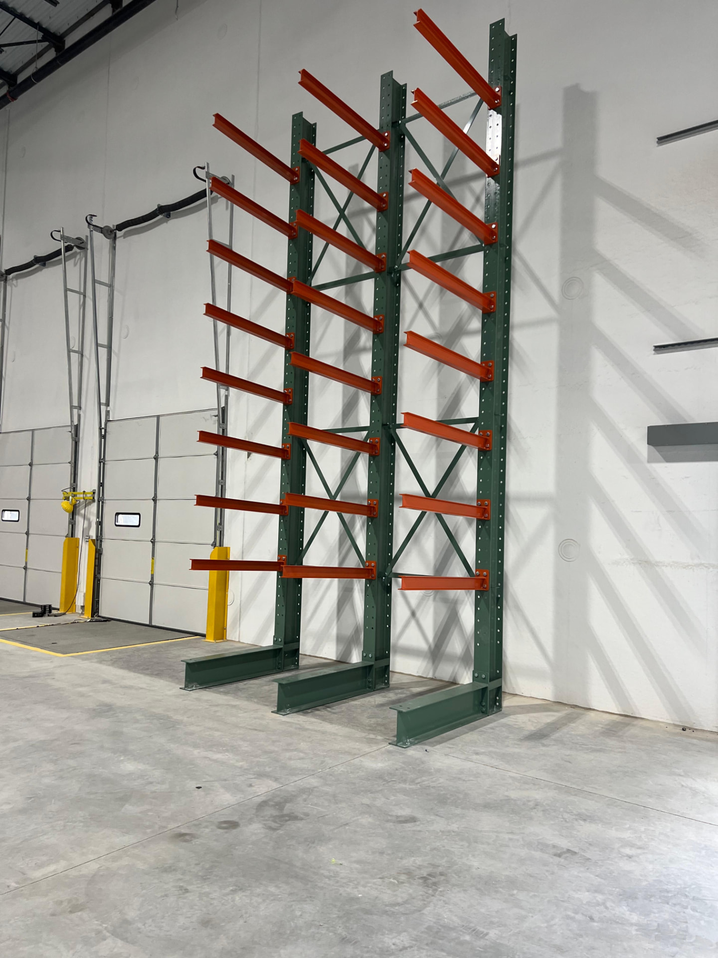 Cantilever rack columns with orange arms installed against a wall